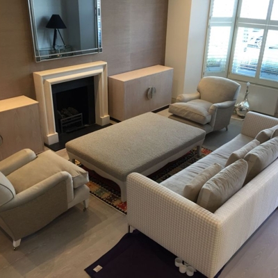 Two storage cupboards with circular brushed stainless steel handles and upholstered coffee table, Chelsea apartment